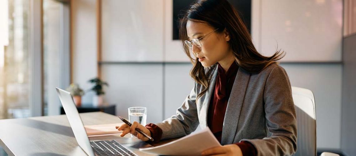 Woman checking files on laptop